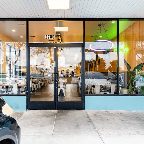 Exterior view of Papas and Eggs restaurant with a bright "OPEN" sign in the window.