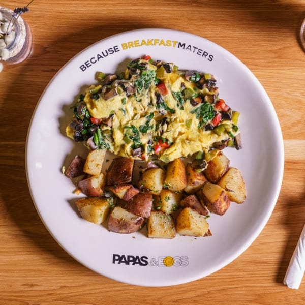 A Papas and Eggs breakfast plate with a vegetable omelet and roasted potatoes.